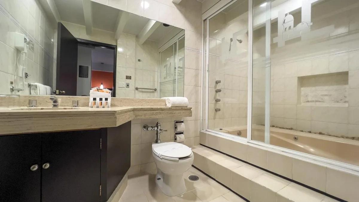 Salle de bain de la Suite Junior à l'Hôtel Catedral. Salle de bain spacieuse avec miroir, lavabo et baignoire.