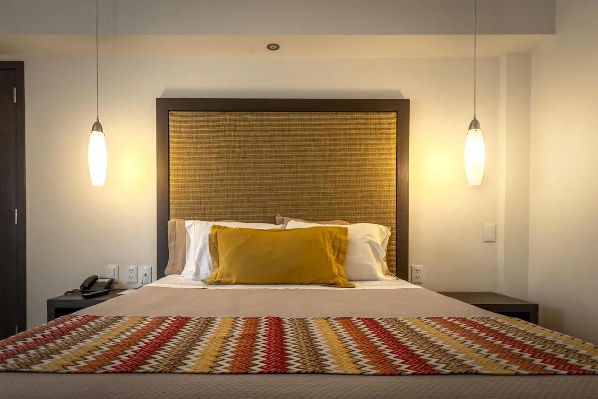 Room view from Hotel Catedral. The bed is in the main frame and a chair is visible. There is a cathedral on the background.